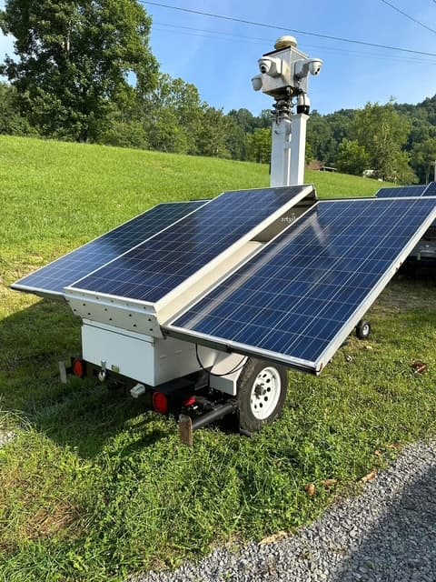 Self-contained solar security camera trailer staged for rapid deployment
